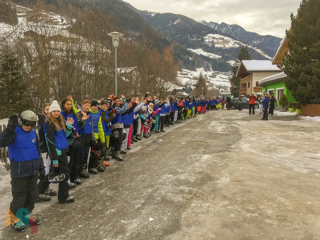 Lange Schlange von Jugendlichen am Straßenrand.